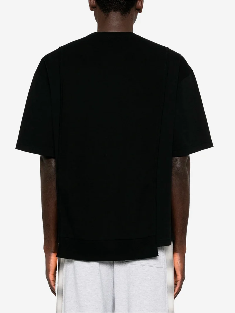 T-shirt nera con grafica 'Undercoverism' e inserti